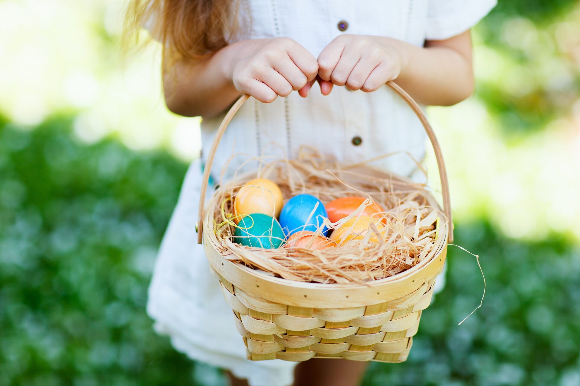 Child carrying an easter basket with eggs